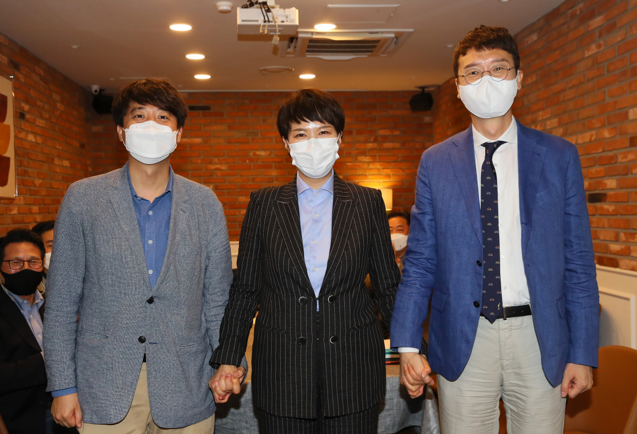 국민의힘 당 대표에 도전하는 김웅(오른쪽 부터), 김은혜 초선 의원과 이준석 전 최고위원이 22일 서울 여의도 정치카페 '하우스'에서 열린 신인 당대표 출마자 초청 토론회에서 손을 맞잡고 기념촬영하고 있다. [연합]