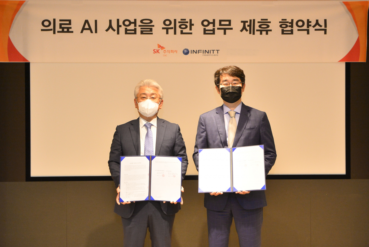 경기도 분당 SK-u타워에서 윤동준 SK㈜ C&C 헬스케어그룹장(왼쪽)과 김동욱 인피니트헬스케어 대표가 ‘AI 뇌출혈 영상판독 솔루션, 인피니트 팩스(INFINITT PACS) 연계 공급 계약’ 체결 후 기념 촬영을 하고 있다 [SK㈜ C&C 제공]