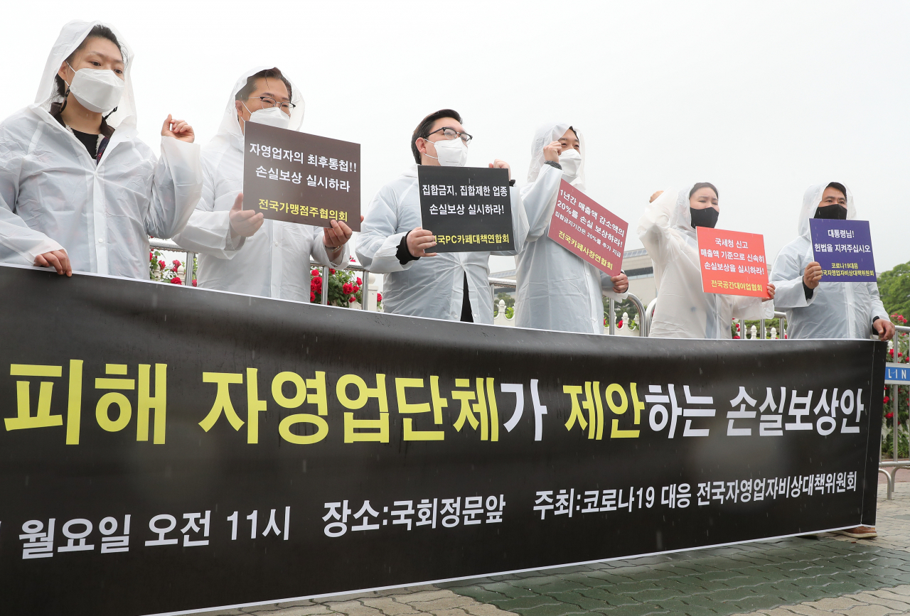 지난 17일 국회 앞에서 열린 코로나19 피해 자영업자단체 손실보상안 제안 기자회견에서 참석자들이 손실보상을 촉구하고 있다. [연합]