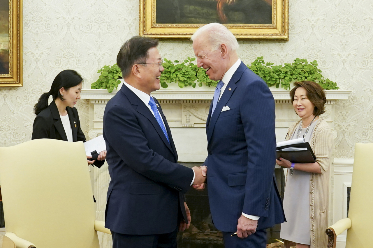 No more fist bumps. Presidents Moon Jae-in and Joe Biden shake hands before a small group meeting at White House in Washington on Friday. (Joint Press Corps-Yonhap)