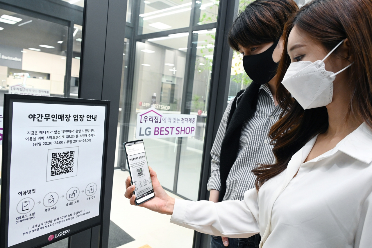 LG전자가 26일부터 국내 가전회사 가운데 처음으로 무인매장을 운영한다. LG전자 모델들이 매장에 들어가기 위해 입구에서 QR코드를 스캔해 본인 인증 절차를 진행하고 있다. [LG전자 제공]