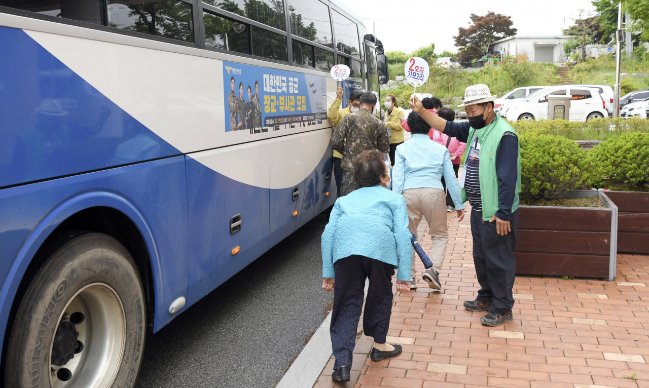 공군 제20전투비행단이 26일 충남 서산시 고북면 행복복지센터에서 코로나19 백신을 접종하러 가는 고북면 거주 75세 이상 어르신의 버스 승차를 돕고 있다. 20전투비행단은 이날 고북면 75세 이상 어르신 40여명을 자체 운행하는 버스에 태워 코로나19 백신 접종장소인 서산종합운동장까지 편안하게 안내했다. [공군 제20전투비행단 제공]
