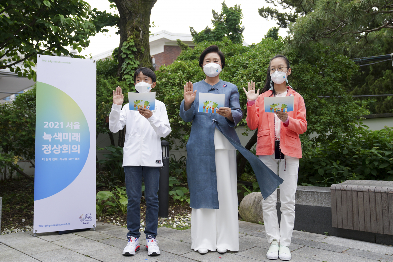 문재인 대통령 부인 김정숙 여사가 26일 서울 종로구 대림미술관에서 열린 '2021 P4G 특별 기획 전시회'에서 어린이들과 '기후 행동 나가자' 선언문을 낭독하고 있다. [연합]