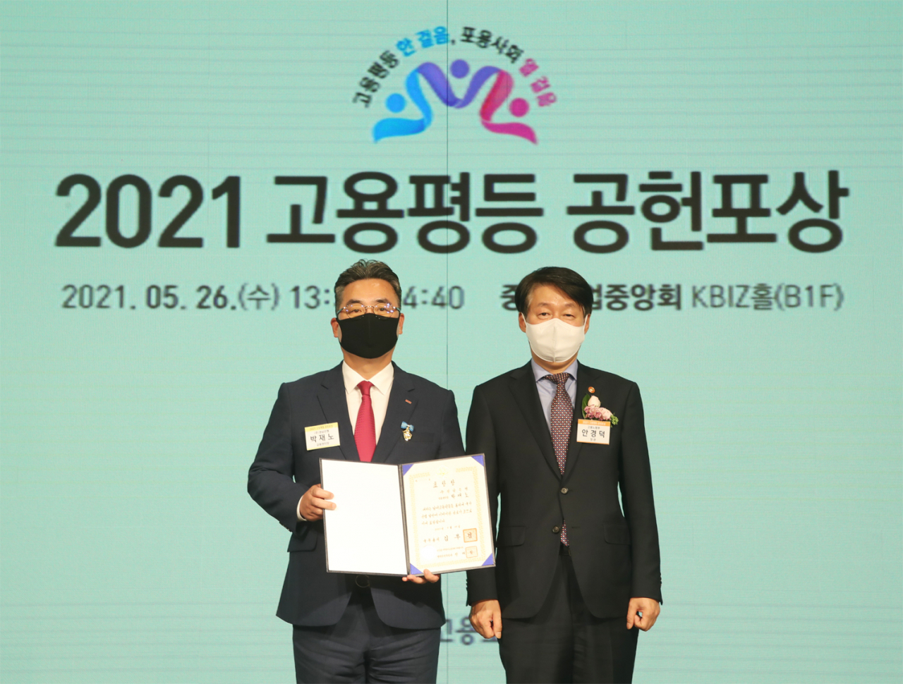 26일 BNK경남은행 박재노 센터장(사진 왼쪽)이 중소기업중앙회 KBIZ홀에서 열린 2021 고용평등 공헌포상 시상식에서 고용노동부 안경덕 장관으로부터 국무총리상을 수상하고 있다.