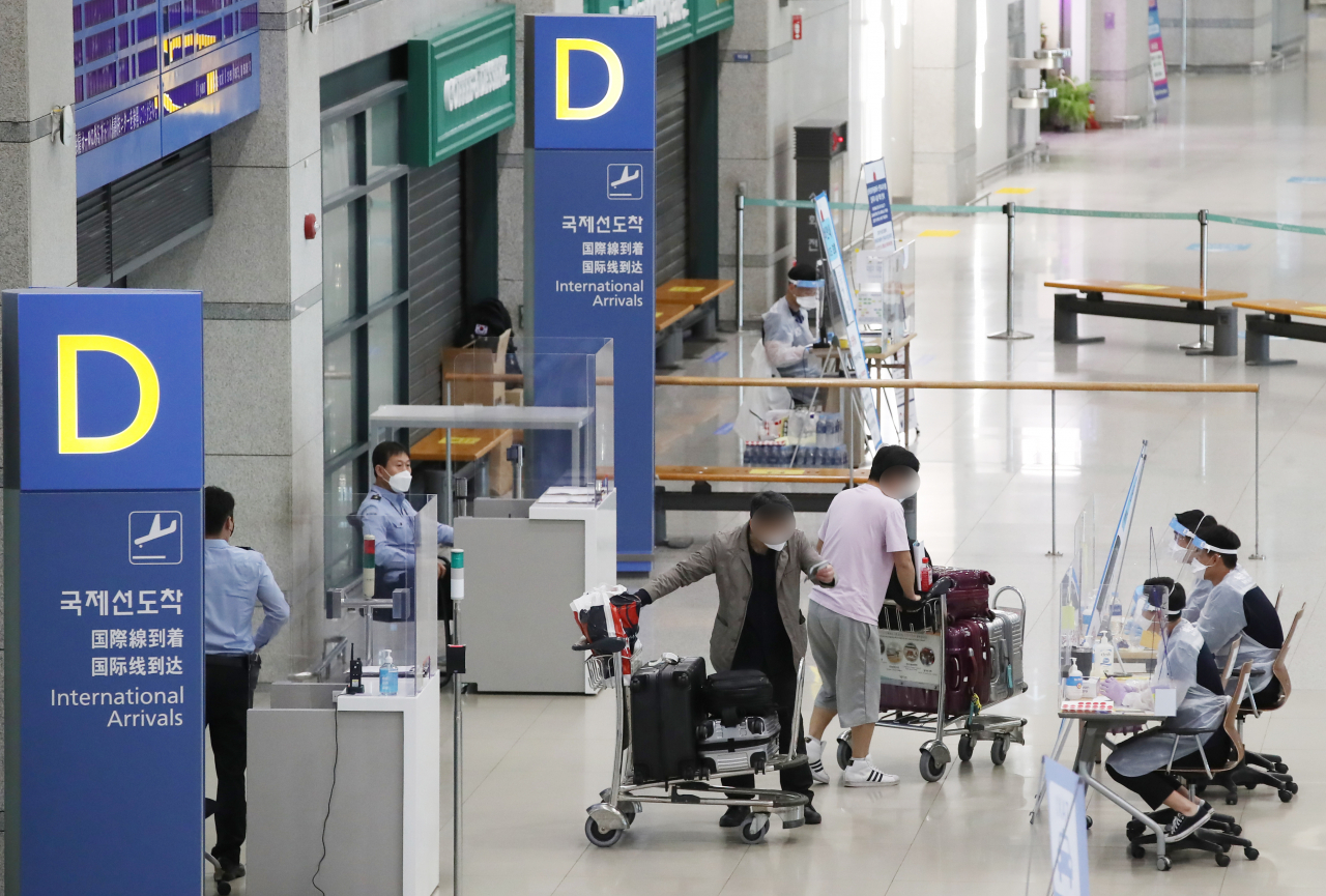 26일 영종도 인천국제공항 1터미널에서 해외입국자들이 검역 절차를 안내받고 있다. 연합뉴스
