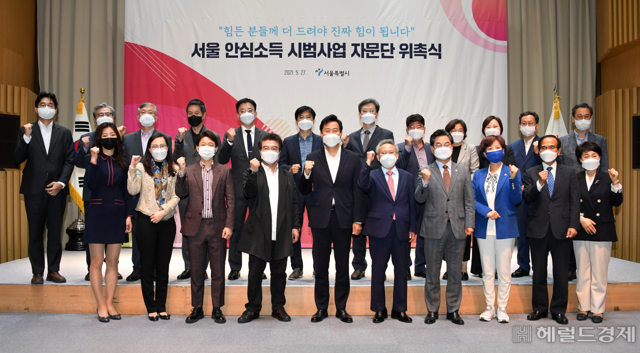 오세훈 서울시장이 27일 오전 10시 시청 대회의실에서 ‘서울 안심소득 시범사업 자문단’ 출범식 후 자문위원들과 화이팅을 외치며 기념사진을 찍고 있다. 안심소득은 상대적으로 생계가 더 어려운 가구를 더 두텁게 지원하는 하후상박(下厚上薄)형 복지제도로, 오세훈 시장의 대표 복지 공약이다. 서울 안심소득 시범사업 자문단은 시범 사업의 설계작업을 맡는다. 분야별로 복지 7명, ·경제‧경영 7명, 고용 1명, 사회과학 4명, 통계 1명 등 각 분야 전문가와 당연직 4명까지 모두 24명으로 구성됐다. jycafe@heraldcorp.com