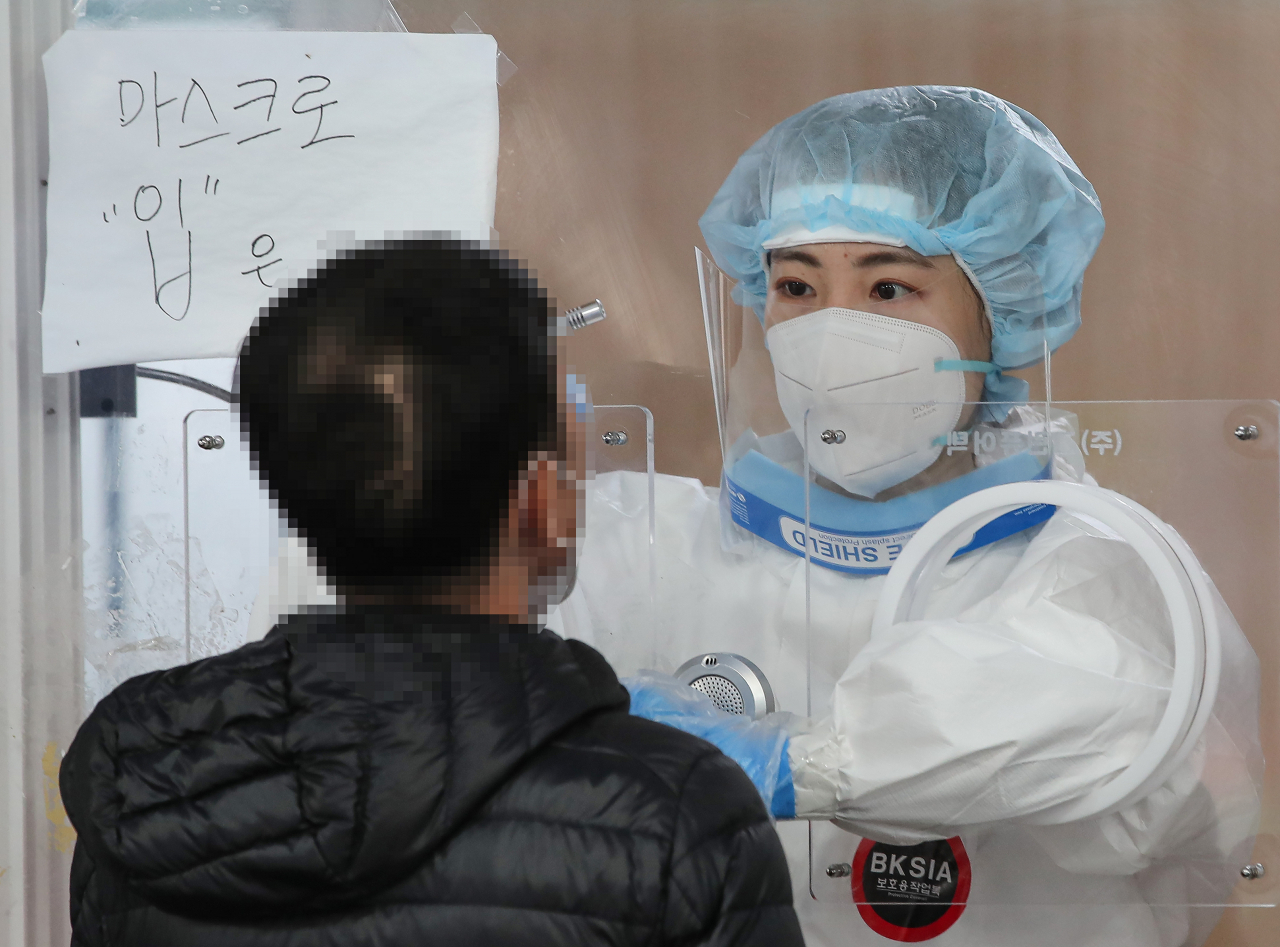 27일 오전 서울 중구 서울역에 설치된 임시 선별검사소에서 검사 담당 관계자가 PCR 검사를 진행하고 있다. 이날 보건 당국은 코로나19 신규확진자가 629명 기록했다고 발표했다. [연합]