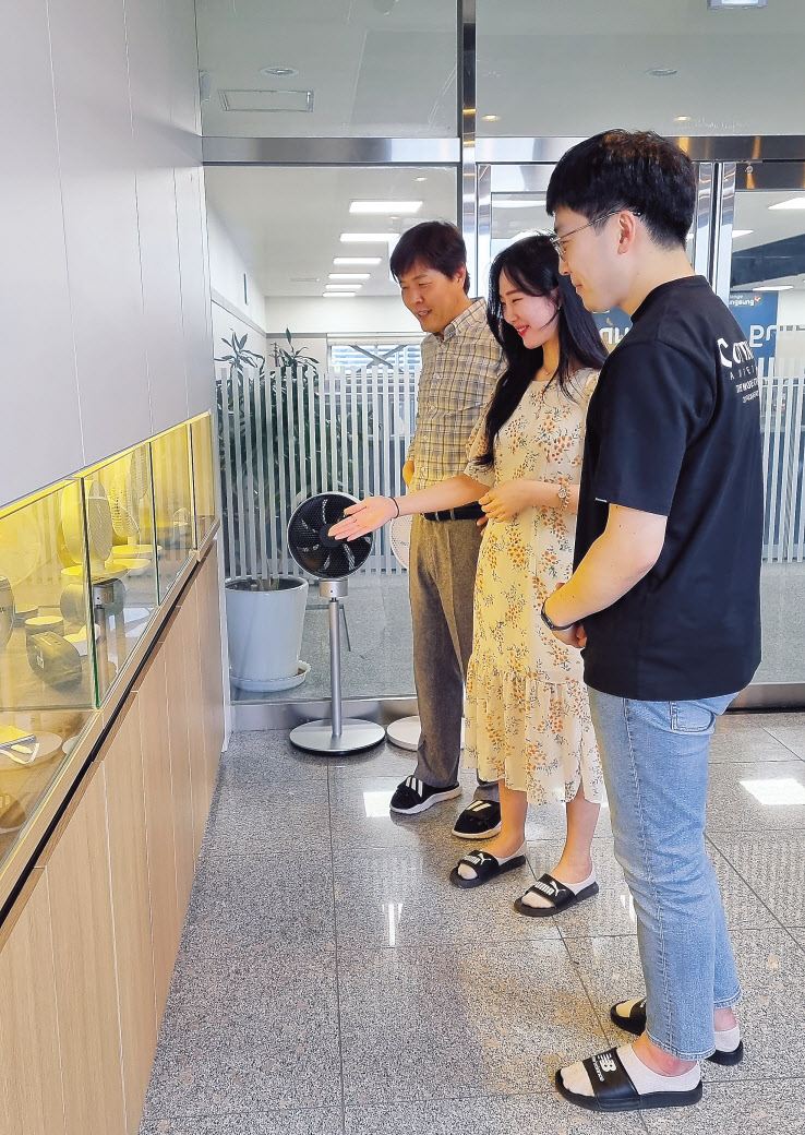 김명용 대표(왼쪽)와 직원들이 핸디형 선풍기 등 자사가 만든 제품들을 살펴보고 있다. [명성 제공]