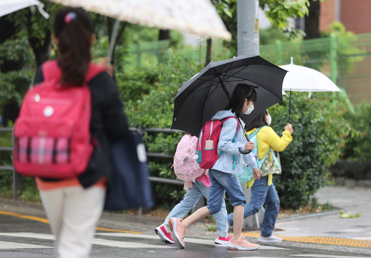 Schoolchildren in a Seoul neighborhood are photographed in face masks on May 17. (Yonhap)