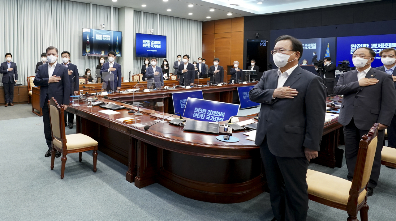정부가 재정 출구전략을 포기하면서 다음 정부부터는 뼈를 깎는 수준으로 예산감축을 해야한다. 그렇지 않는다면 2025년 재정준칙 적용 첫해부터 원칙을 깨게 된다. 27일 청와대에서 열린 국가재정전략회의에 참석, 국기에 경례하고 있는 문재인 대통령. 김부경 국무총리(오른쪽)와 그 뒤에 선 홍남기 부총리 겸 기획재정부 장관. [연합]