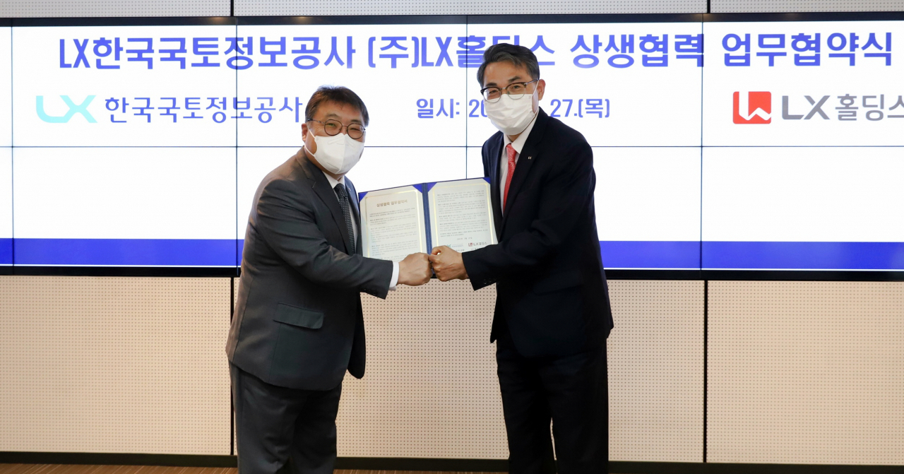 LX홀딩스 송치호 사장(왼쪽)과 LX한국국토정보공사 김정렬 사장이 27일 LX공사 서울지역본부에서 열린 상생협력을 위한 협약을 맺은 후 기념촬영을 하고 있다. [LX홀딩스 제공]