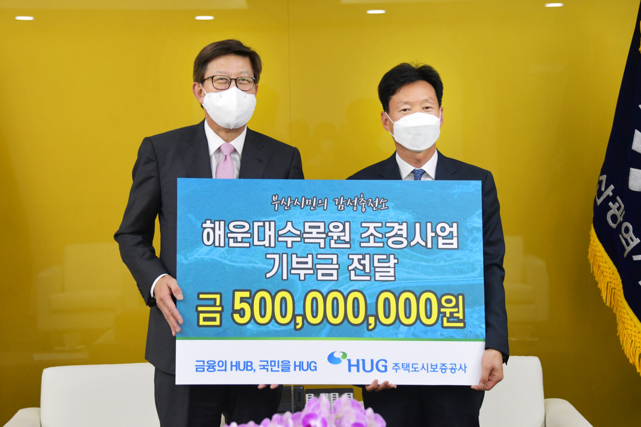 지난 27일 부산시청에서 열린 해운대 수목원 조성 사업 기부금 전달식에서 박형준 부산시장(왼쪽), 이병훈 주택도시보증공사(HUG) 부사장이 기념 촬영을 하는 모습. [HUG 제공]