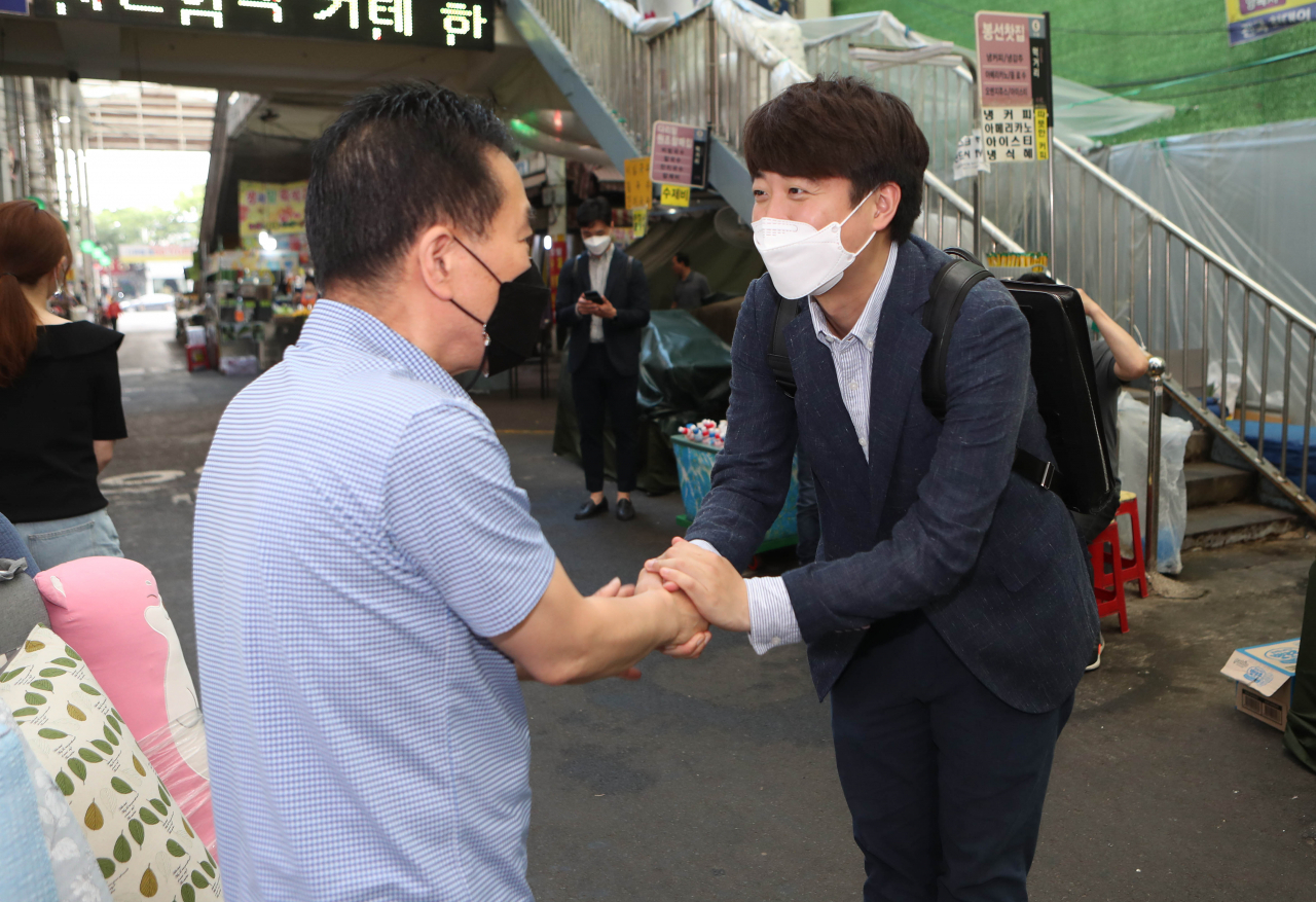 국민의힘 당권에 도전하는 지난 이준석 전 최고위원이 24일 오전 대구 중구 서문시장을 찾아 상인과 인사를 하고 있다. [연합]