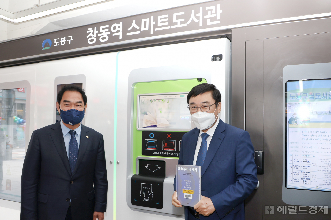 27일 창동역 스마트도서관 개관식에서 이동진(오른쪽) 구청장이 스마트도서관에서 빌린 책을 들어보이고 있다. [도봉구 제공]