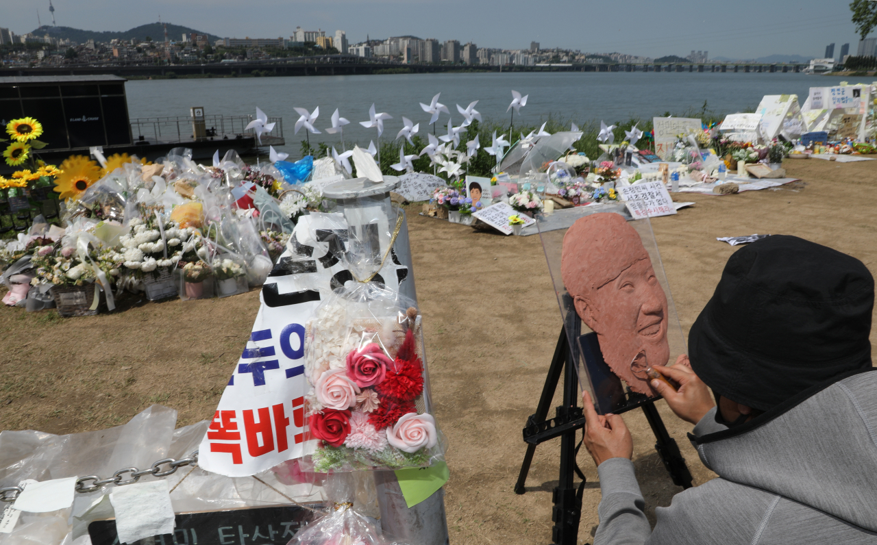 30일 서울 서초구 반포한강공원 내 고(故) 손정민 씨 추모 현장에서 한 시민이 손씨의 얼굴을 만들고 있다. 이날 경찰은 손씨 친구 A씨의 휴대전화를 환경미화원이 습득해 제출했다고 밝혔다. [연합]