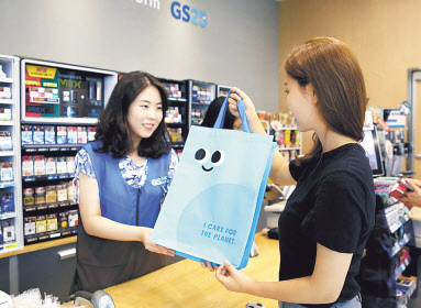 고객이 GS25 매장에서 ‘친환경 쇼핑백’을 구매하고 있는 모습. [GS 제공]