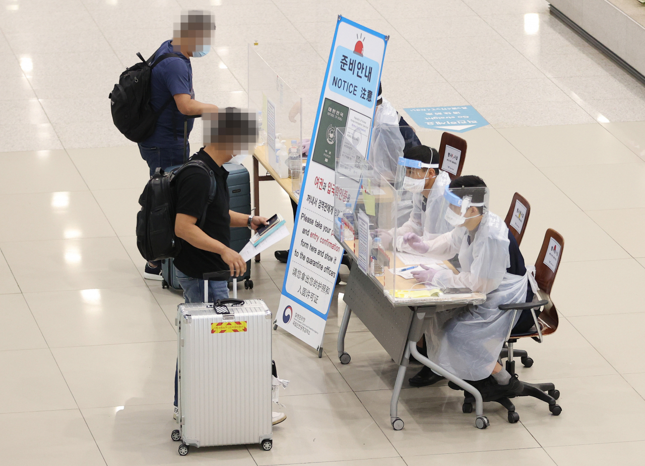 최근 인천국제공항 제1터미널로 입국한 여행자들이 육군 검역지원단으로부터 안내를 받고 있다. [연합]