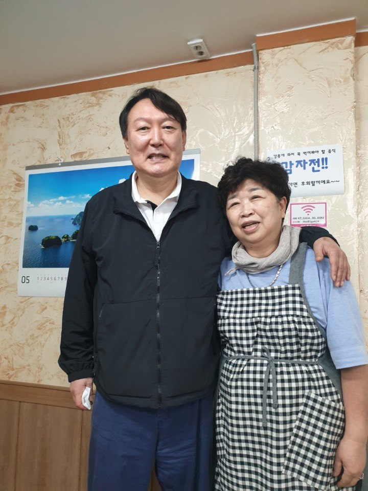 윤석열 전 검찰총장이 지난달 29일 강원 강릉시 강릉중앙시장 인근 감자바우 식당에서 음식점 사장과 기념사진을 찍고 있다. [연합]