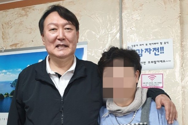 윤석열 전 검찰총장이 강원 강릉시 강릉중앙시장 인근 감자바우 식당에서 음식점 사장과 기념사진을 찍고 있다. [연합]