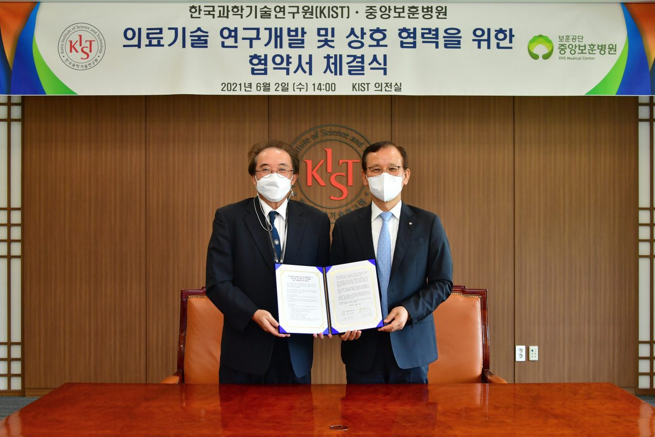 유근영(왼쪽) 중앙보훈병원장과 윤석진 KIST 원장이 협약서에 사인을 마치고 기념촬영을 하고 있다. [KIST 제공]