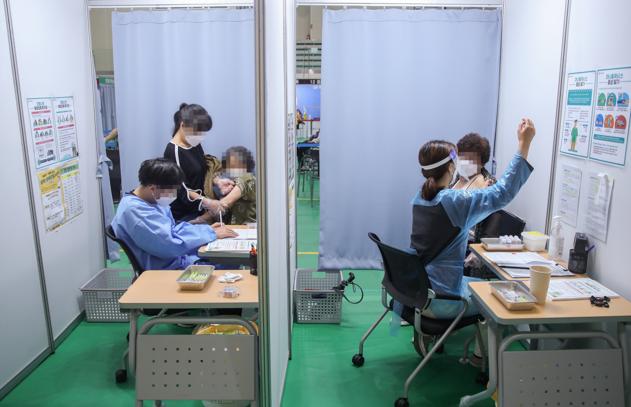 국내에서 신종 코로나바이러스감염증(코로나19) 백신 접종이 시작된 지 100일을 이틀 앞둔 3일 오전 서울 중랑문화체육관에 마련된 접종센터에서 의료진이 백신 접종을 하고 있다. 연합뉴스