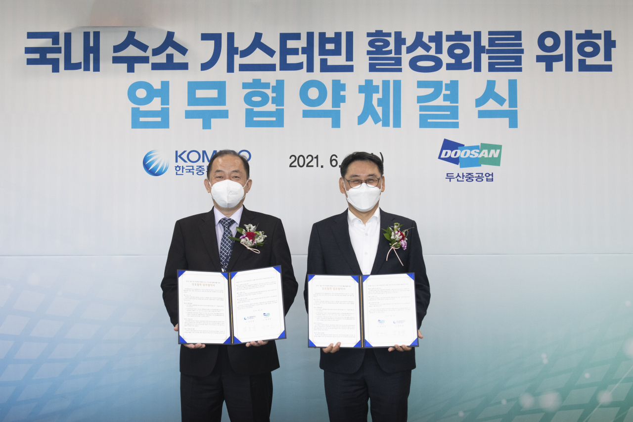 한국중부발전 김호빈사장(왼쪽)과 두산중공업 정연인 사장이 2일, 한국중부발전 본사에서 '국내수소가스터빈 활성화'를 위한 업무협약 체결 후 기념사진을 촬영하고 있다. [두산중공업 제공]