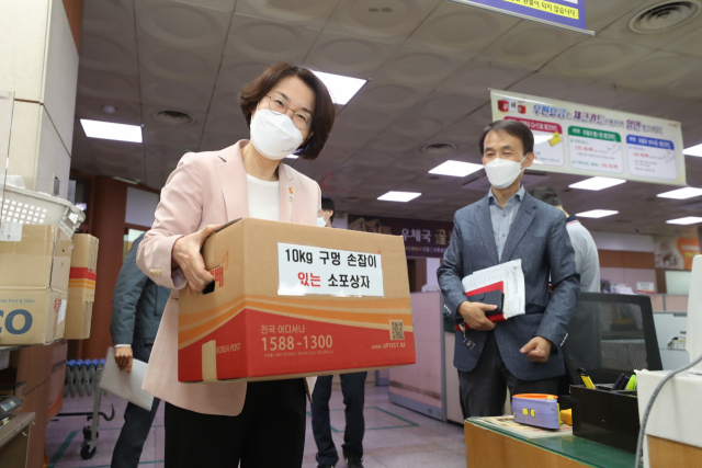 임혜숙 과기정통부 장관이 4일 서울 송파우체국에서 안전관리 실태를 점검했다. 임 장관이 구멍 손잡이 소포상자를 들고 포즈를 취하고 있다 [과기정통부 제공]