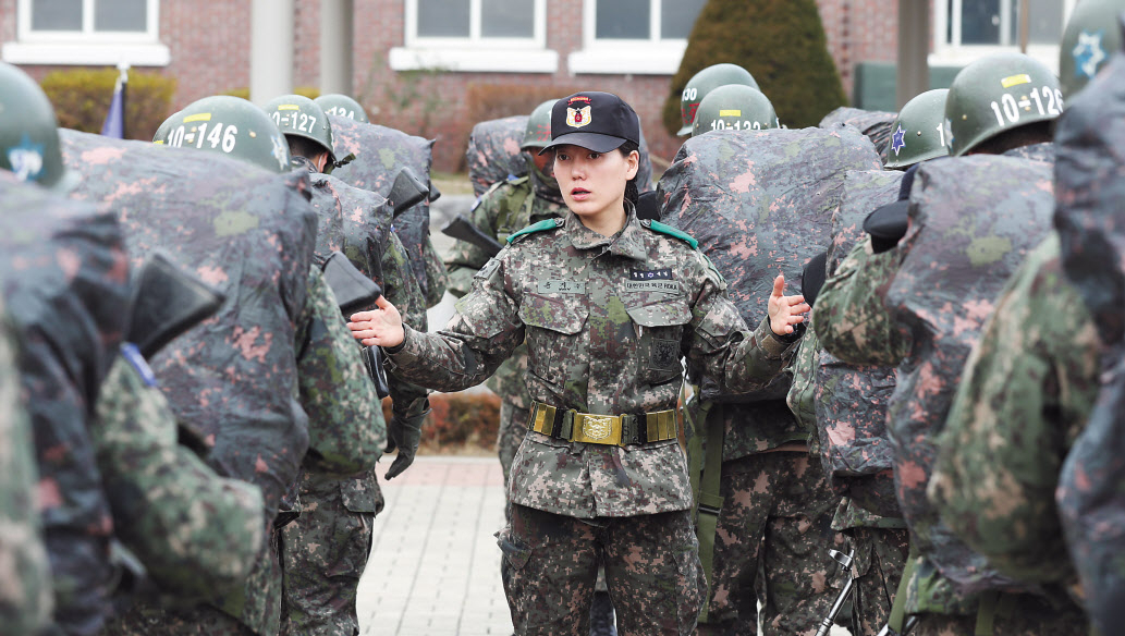 병역 의무를 둘러싼 이십대 청년세대의 ‘젠더갈등’과 최근 공군 여중사 성폭력 피해 사건 등으로 여군에 대한 사회적 관심이 높아진 가운데, 운명처럼 군복을 입게 된 윤지수 상사의 이야기를 들어봤다. 실업여자축구 WK리그 선수 출신인 윤 상사는 육군에서 모범적인 신병훈련 교관으로 ‘대체불가 부사관’으로 뽑혔고, 60여회의 헌혈과 소아암 환자를 위한 머리카락 기부 등으로도 ‘육군의 자랑’이 됐다. 사진은 윤 상사가 행군에 나서는 훈련병들의 군장을 점검하고 있는 모습이다. [국방일보 제공]