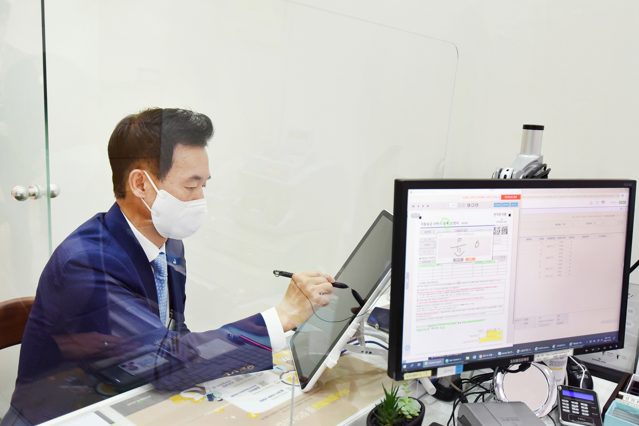 윤열현 교보생명 대표이사가 고객플라자 창구에서 전자문서 업무를 시연해보고 있다. [교보생명 제공]