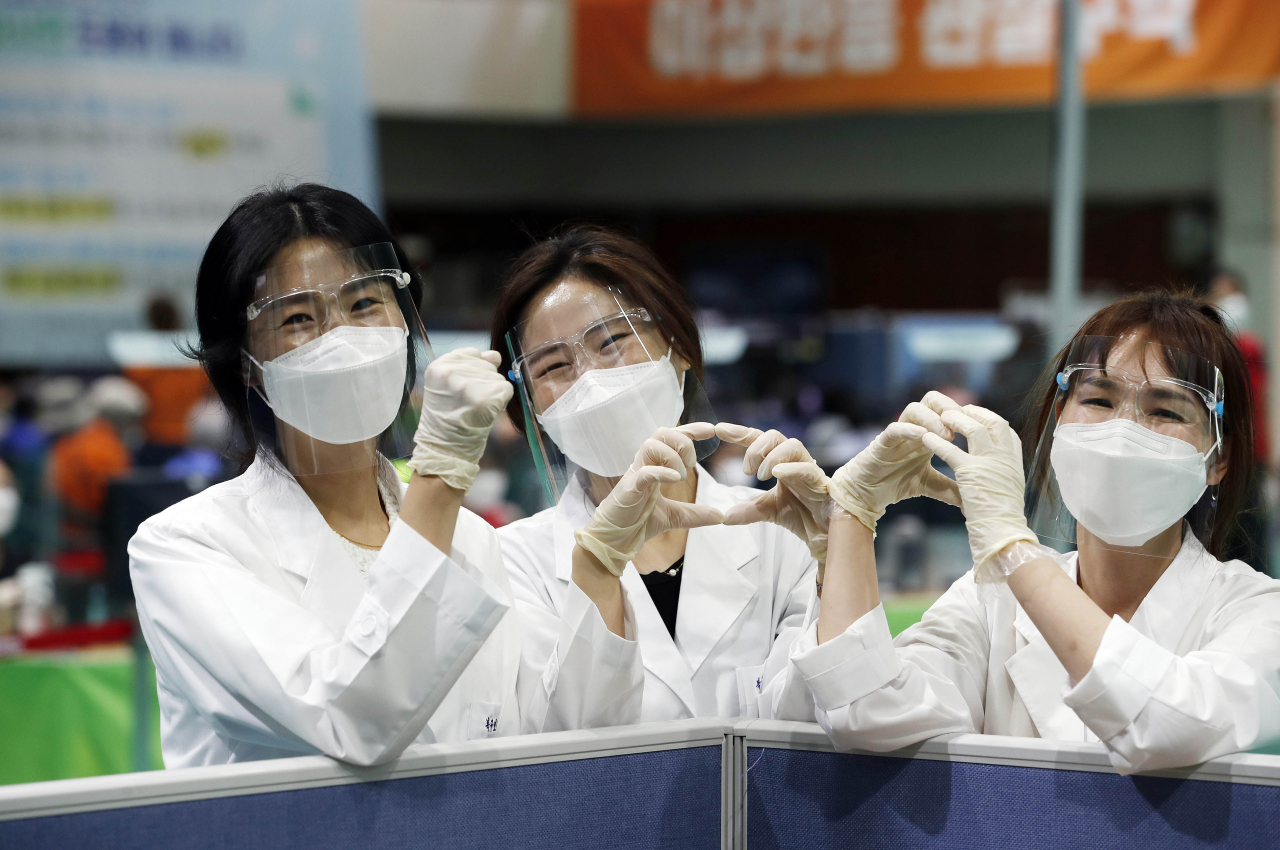 국내에서 코로나19 백신 접종이 시작된 지 100일을 하루 앞둔 4일 오후, 광주광역시 북구 백신 예방접종센터에서 보건소 의료진이 내일이 백신 접종을 시작한 지 100일째 되는 날이라는 소식을 듣고 손으로 숫자 '100'을 만들어 보이고 있다. [연합]