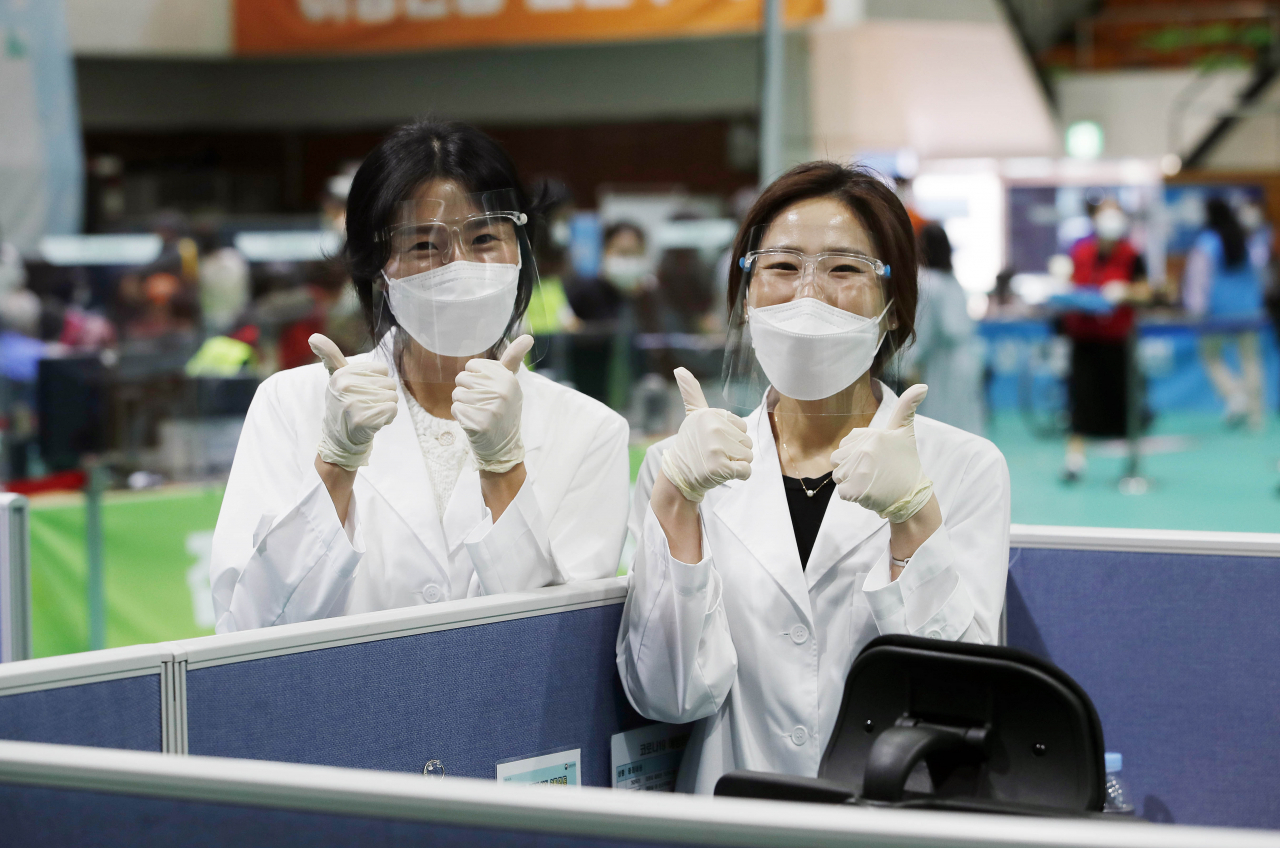 국내에서 코로나19 백신 접종이 시작된 지 100일을 하루 앞둔 4일 오후 광주 북구 백신 예방접종센터에서 보건소 의료진이 내일이 백신 접종을 시작한지 100일째 되는 날이라는 소식을 듣고 엄지를 들어보이며 웃고 있다. 연합뉴스