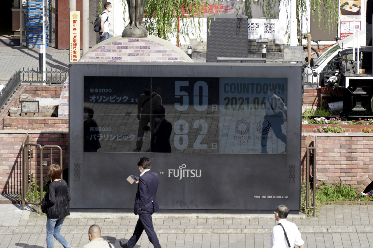 일본 도쿄의 심바시역 부근에서 3일 하계올림픽이 50일 앞으로 다가왔음을 알리는 시계 앞으로 행인들이 지나가고 있다. 도쿄 올림픽은 오는 7월 23일 개막해 8월 8일 폐막할 예정이다. 연합뉴스