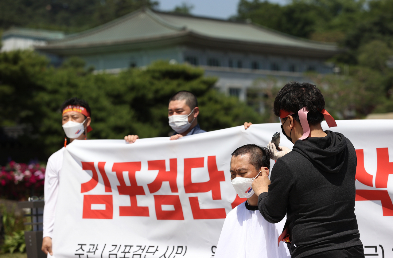 김포·인천 검단지역 시민단체 회원들이 4일 오후 서울 청와대 분수대 앞에서 광역급행철도(GTX) D 노선의 강남 직결과 서울지하철 5호선 김포 연장 등을 촉구하며 삭발을 하고 있다. [연합]
