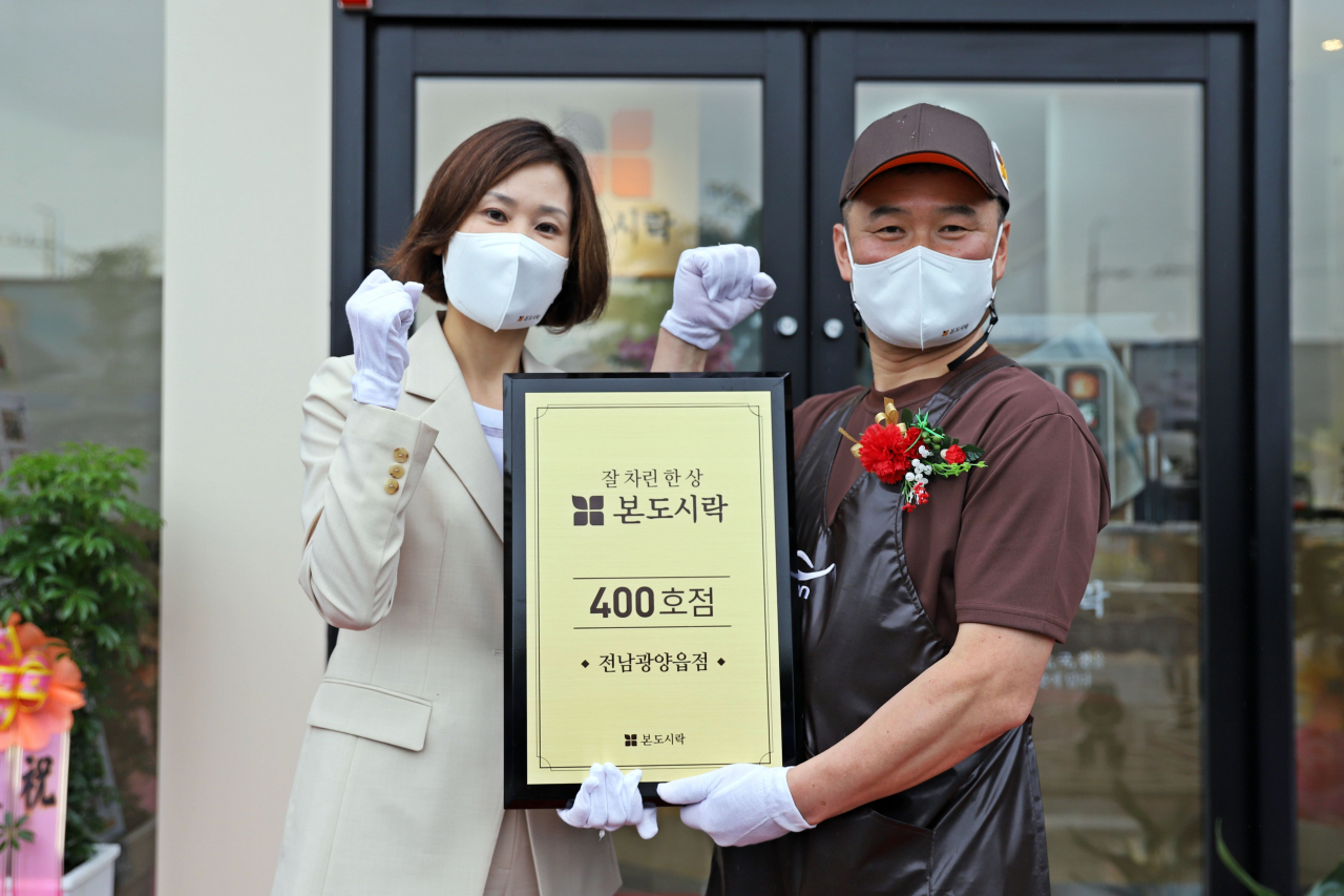 이진희 본아이에프 대표이사(사진 왼쪽)는 지난 3일 전남 광양읍에 본도시락 400호점 오픈을 기념해 현판식을 전달한 후 기념사진을 찍고 있다. [본아이에프 제공]