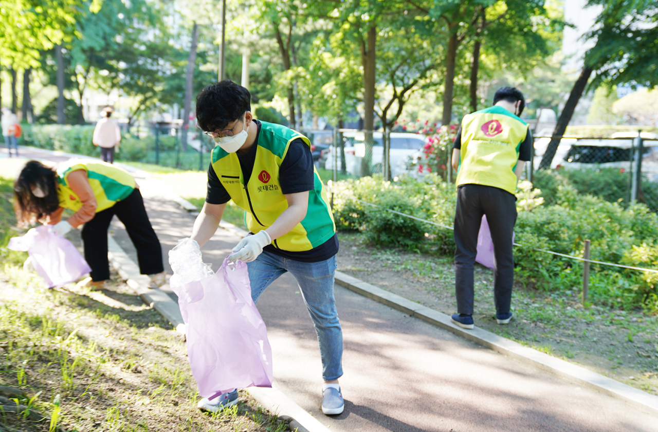 롯데건설 샤롯데봉사단이 서울 잠원동 본사 인근에서 임직원 ‘걸음 기부 캠페인’의 일환인 줍깅 챌린지에 참여하고 있다. [롯데건설 제공]