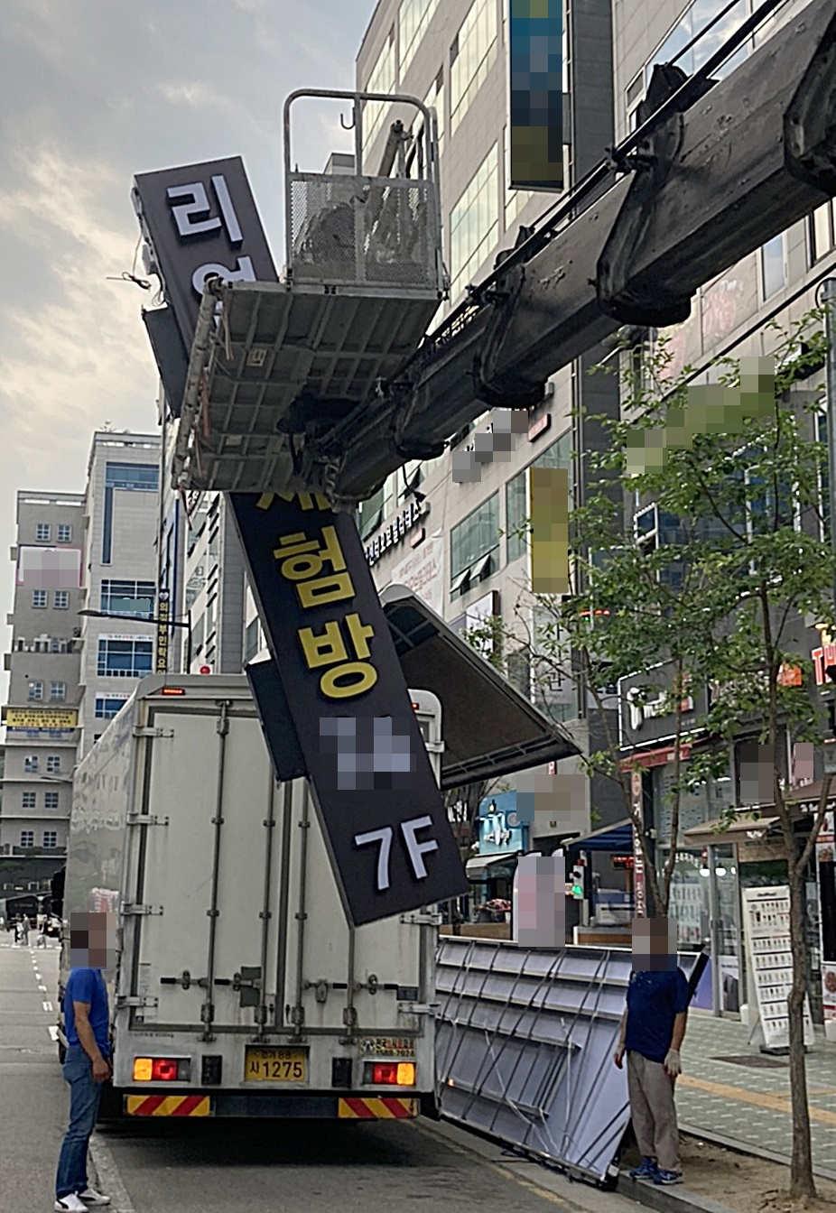 최근 논란이 된 경기 의정부시 내 리얼돌 체험방이 7일 오후 간판을 철거하고 있다.[연합]