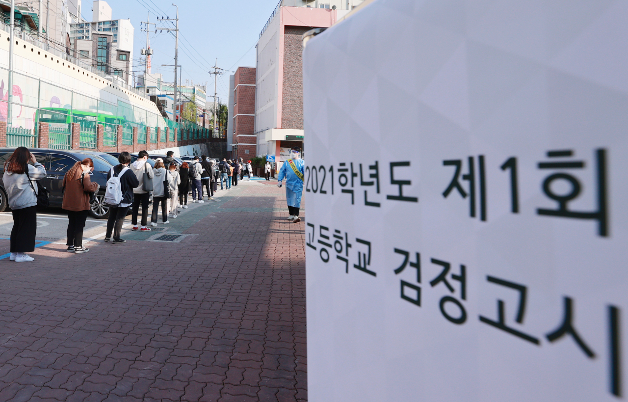 지난 4월10일 오전 서울 성북구 월곡중학교에서 열린 고졸 학력인정 검정고시에 응시한 수험생들이 거리두기를 하며 차례대로 고사장에 입실하고 있다. [연합]