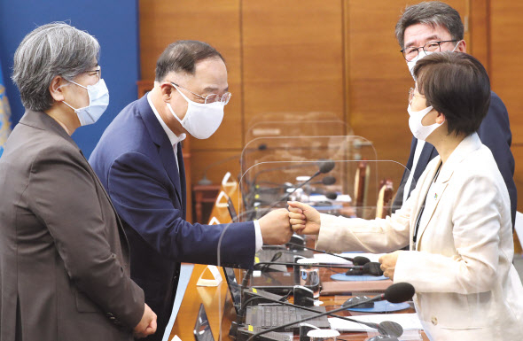 추가세수가 들어왔지만, 정부가 지출을 줄일 생각을 하지 않으면서 재정적자 행진은 계속될 전망이다. 7일 청와대에서 열린 제3차 코로나19 대응 특별방역점검회의에서 홍남기 경제부총리 겸 기획재정부 장관(가운데)과 기모란 청와대 방역기획관이 인사하고 있다. 왼쪽은 정은경 질병관리청장. [연합]