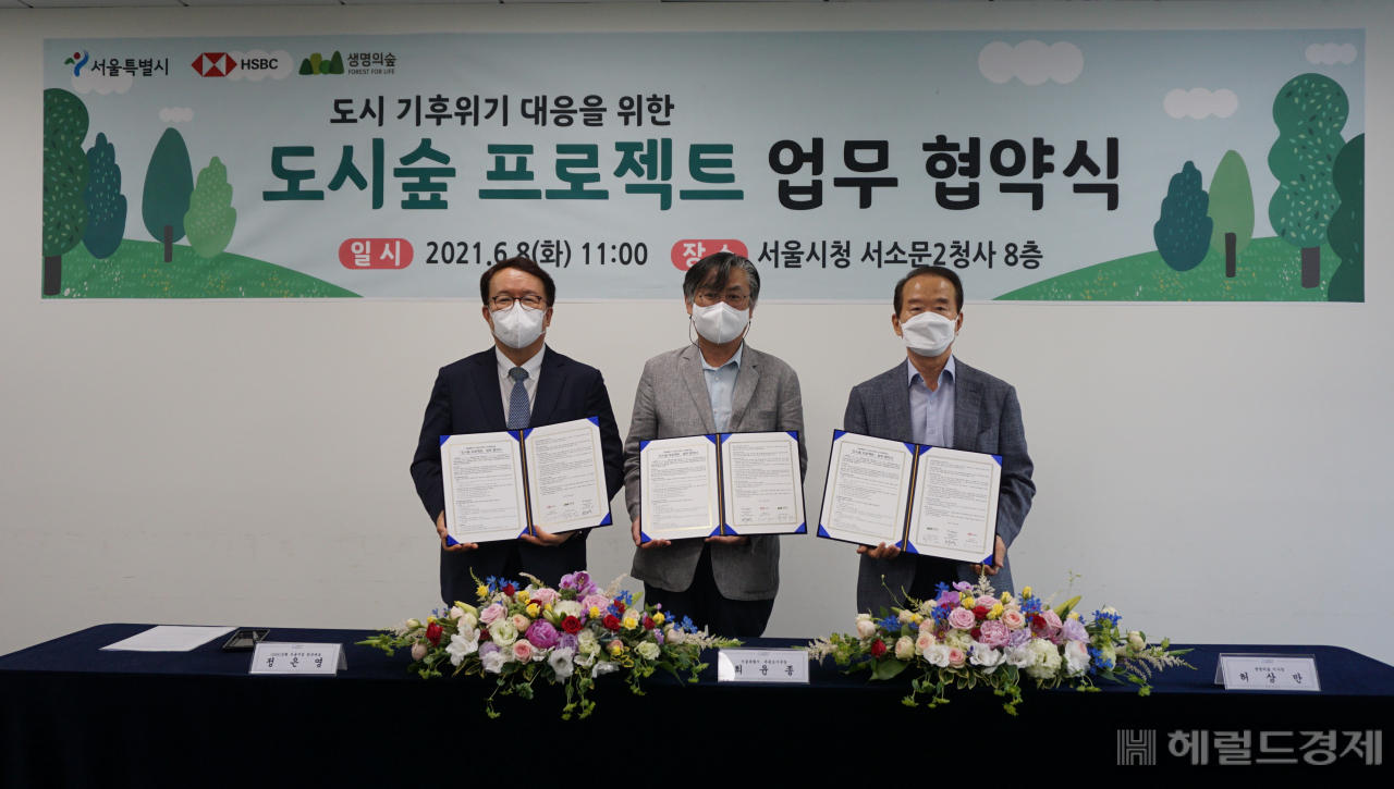 8일 업무협약식에서 정은영(왼쪽부터) HSBC코리아 대표 , 최윤종 서울시 푸른도시국장, 허상만 생명의숲 이사장이 협약서에 서명한 뒤 협약서를 들어보이고 있다. [서울시 제공]