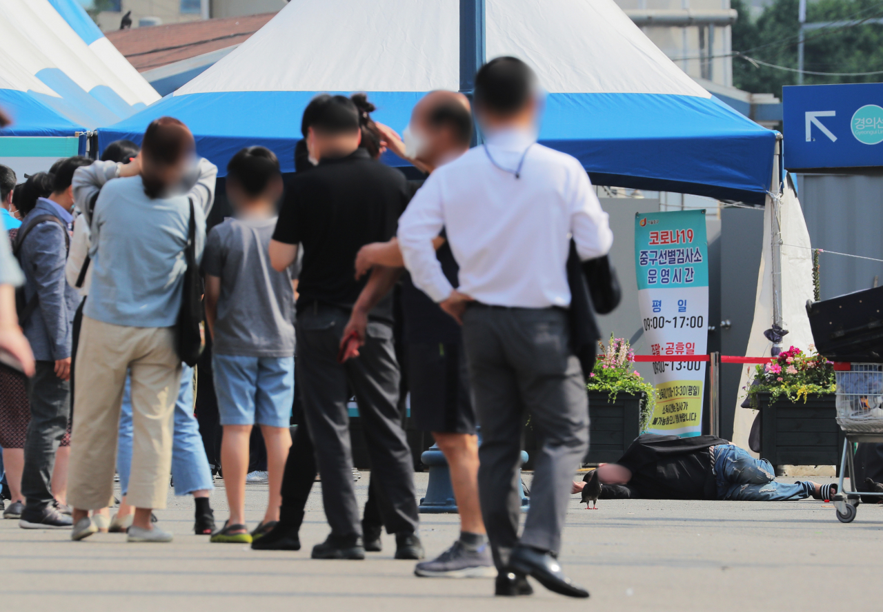 8일 오전 서울역 광장 중구임시선별검사소 앞에서 한 노숙자가 잠을 청하고 있다. [연합]