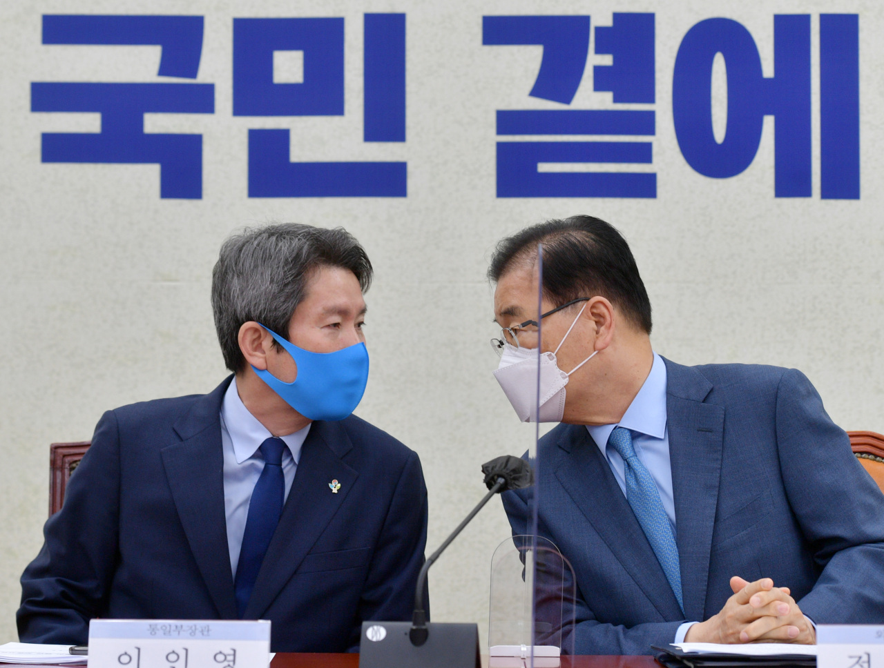 Unification Minister Lee In-young (left) speaks with Foreign Minister Chung Eui-yong during a ruling party-government consultation session at the National Assembly in Seoul on Wednesday. (Yonhap)