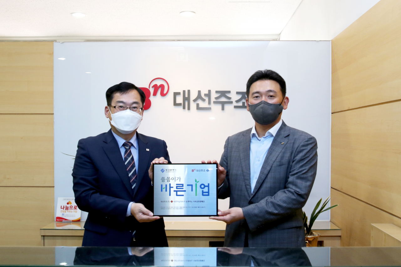 9일 대선주조 본사에서 대한적십자사 부산광역시지사 최성필 사무처장(왼쪽)이 대선주조 조우현 대표에게 ‘씀씀이가 바른기업’ 명패를 전달하고 있다. [대선주조 제공]