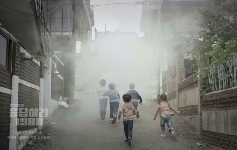 마을 골목의 감성은 세계적인 여행상품이 될수 있다. 한국에서의 인기에서 이어, 최근까지 세계적인 역주행을 보인 TVN 드라마 ‘응답하라 1988’ 한 장면. 오른쪽의 어린 덕선이가 후미에서 소독차를 뒤따라가고 있다.