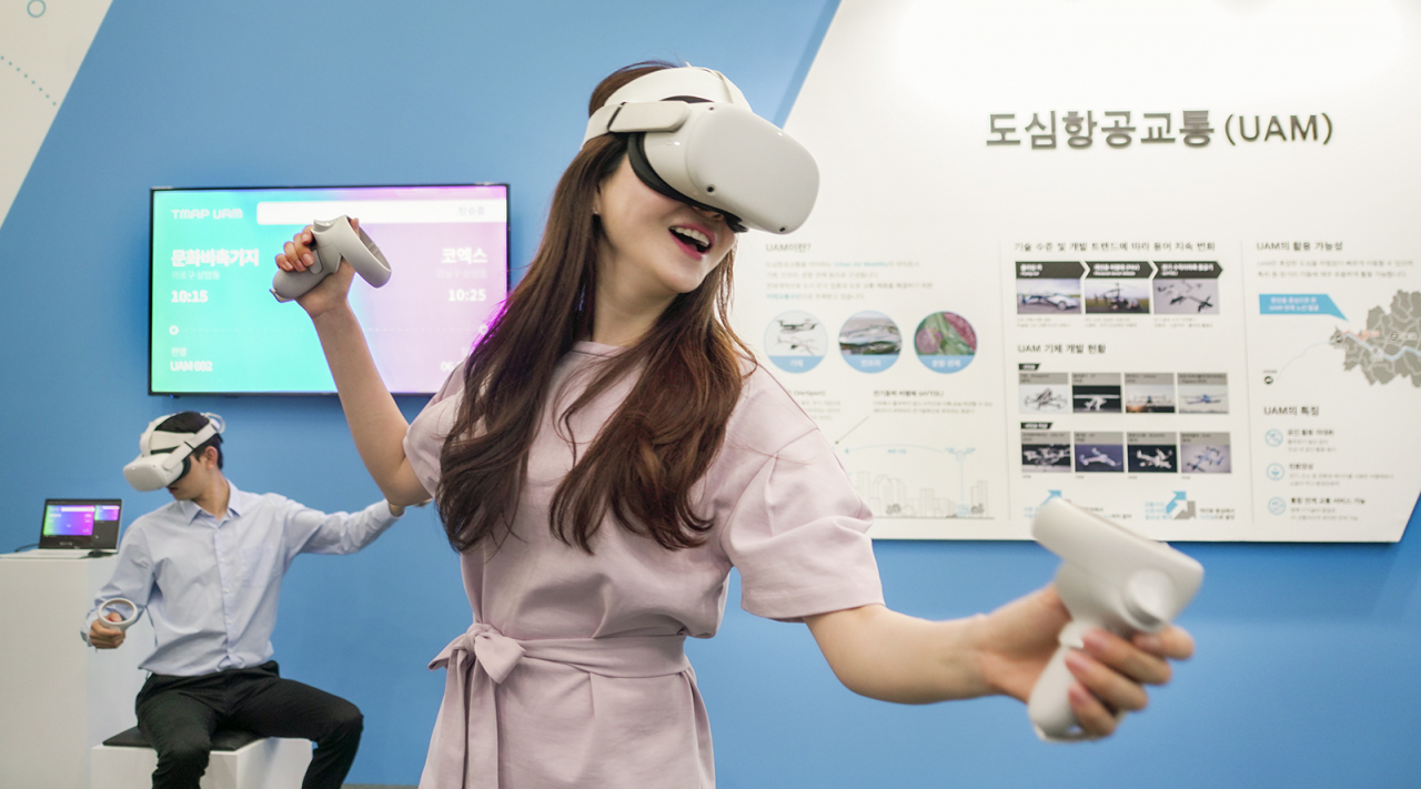 SK텔레콤 모델이 ‘2021 서울 스마트 모빌리티 엑스포(SSME 2021)’에서 가상현실(VR)로 구현된 도심항공교통(UAM) 콘텐츠를 통해 상암동에서 코엑스까지 이동하는 가상 체험을 하는 모습 [SK텔레콤 제공]