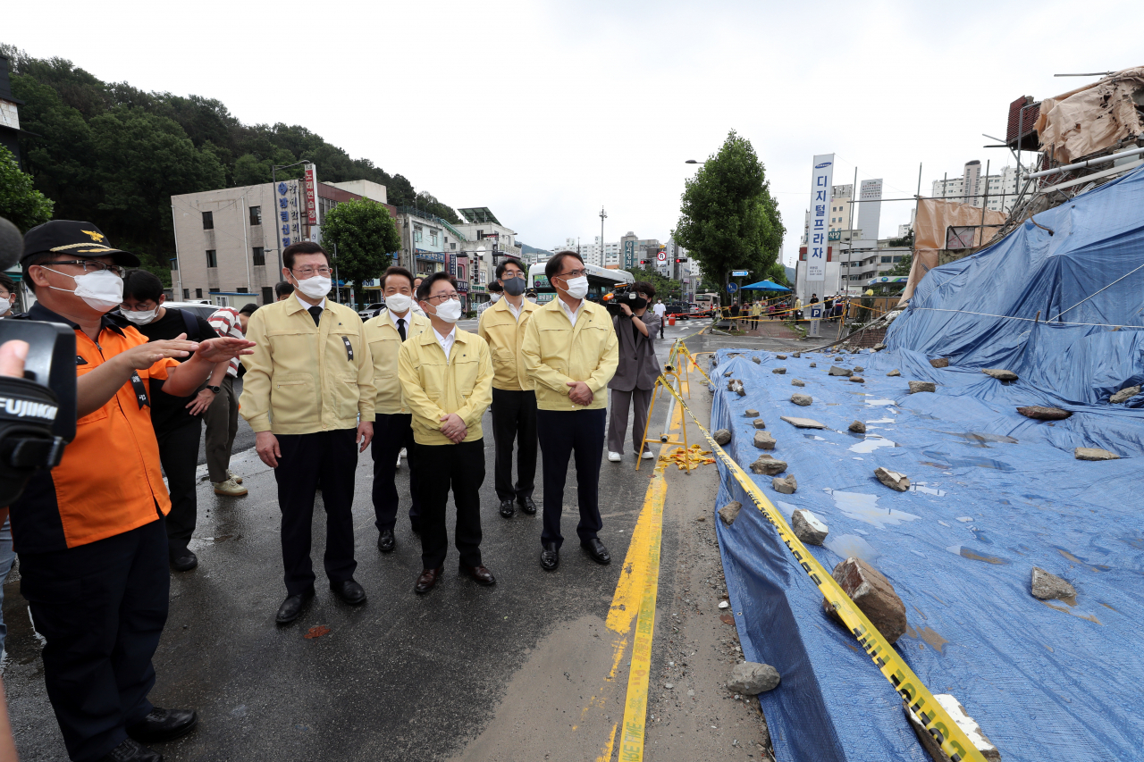 11일 오전 박범계 법무부 장관(가운데)이 광주 동구 학동 재개발지역의 철거건물 붕괴 사고 현장을 찾아 현황을 설명 듣고 있다. [연합]