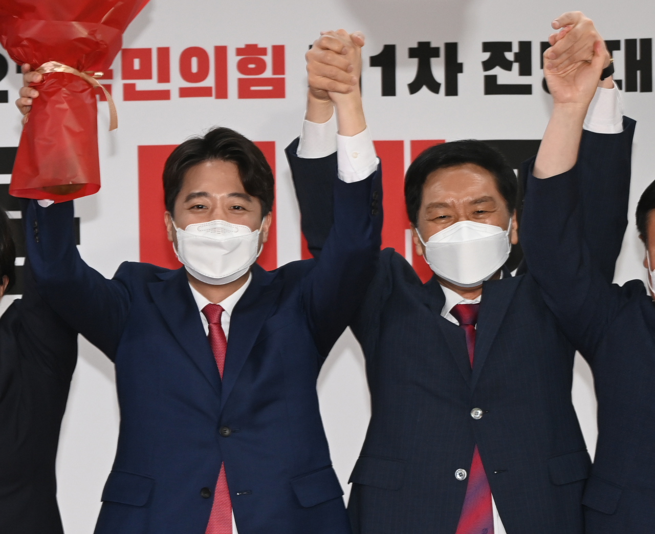 이준석 국민의힘 새 대표(왼쪽)가 11일 서울 여의도 중앙당사에서 열린 전당대회에서 김기현 원내대표와 함께 손을 잡고 기뻐하고 있다. [연합]