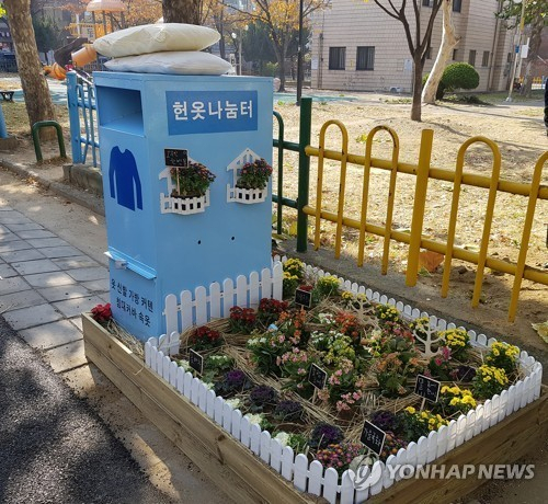 쓰레기를 무단투기하는 일이 없도록 지자체가 폐의류 수거함 옆에 화단을 조성한 모습.