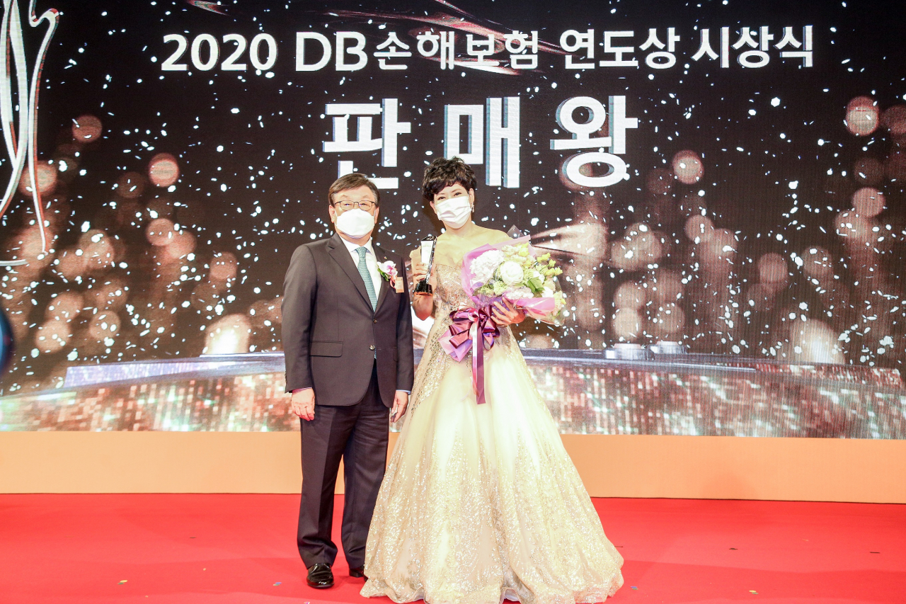 김정남 DB손해보험 대표이사 부회장(왼쪽)이 2020 연도상 시상식에서 판매왕에 선정된 황금숙 남부사업단 PA(오른쪽)와 기념촬영을 하고 있다. [DB손해보험 제공]