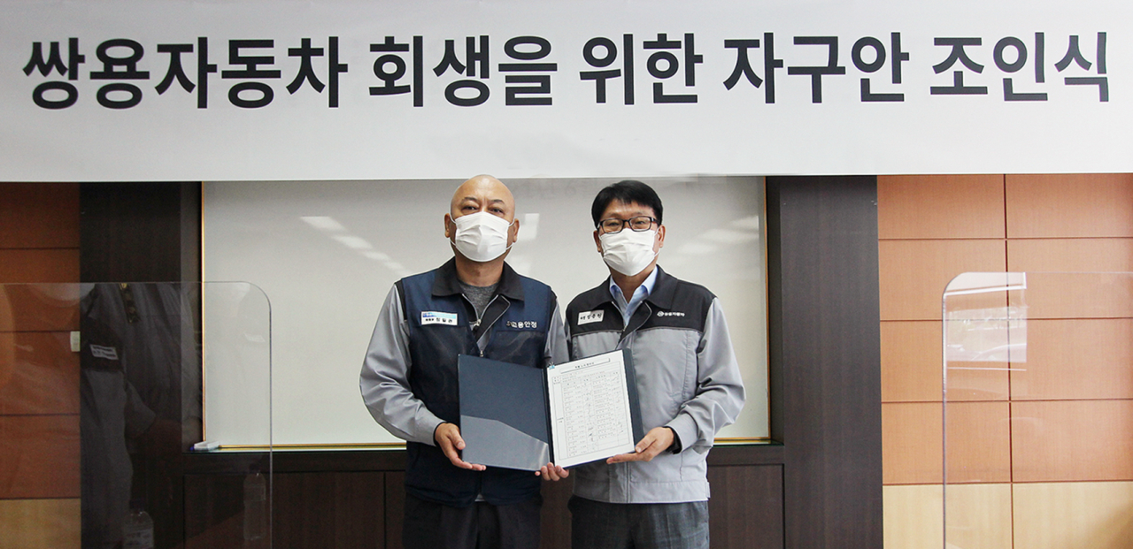 14일 쌍용차 회생을 위한 조인식에서 정용원 관리인(오른쪽)과 정일권 노동조합 위원장이 합의안에 서명한 후 기념촬영을 하고 있다. [쌍용차 제공]