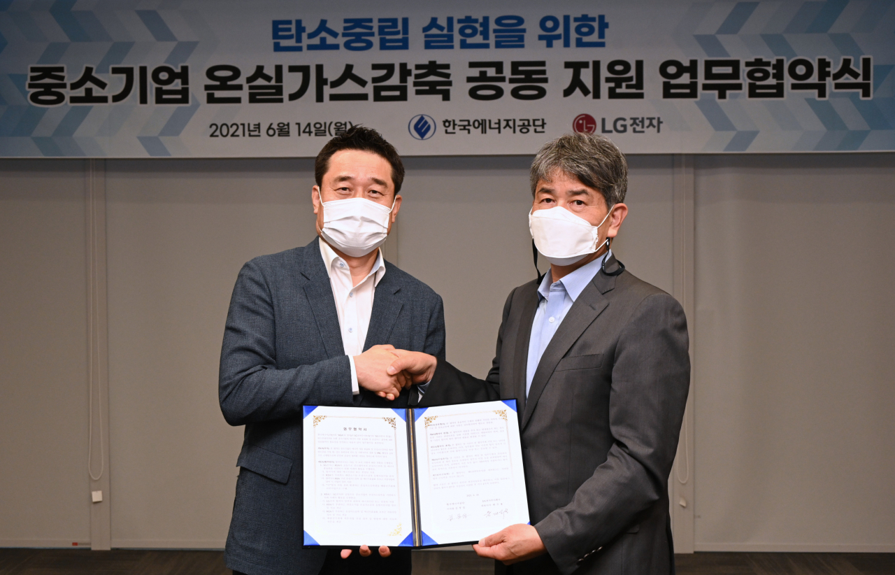 LG전자와 한국에너지공단이 14일 경기도 수원시에 있는 수원컨벤션센터에서 중소기업의 온실가스 감축 및 에너지 효율화를 위한 업무협약을 체결했다. LG전자 대외협력담당 윤대식 전무(왼쪽)와 한국에너지공단 김창섭 이사장이 기념촬영을 하고 있다. [LG전자 제공]